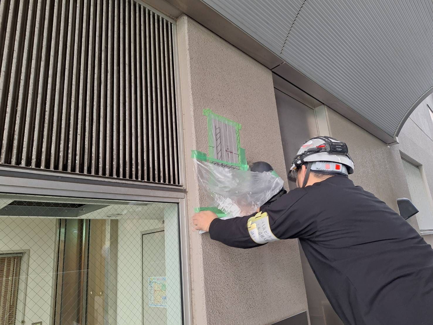 大阪のビル工事現場でビニール養生を行うHOLTECHのスタッフ