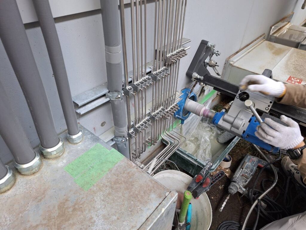 大阪の設備機械室で乾式コア抜きを行うHOLTECH職人